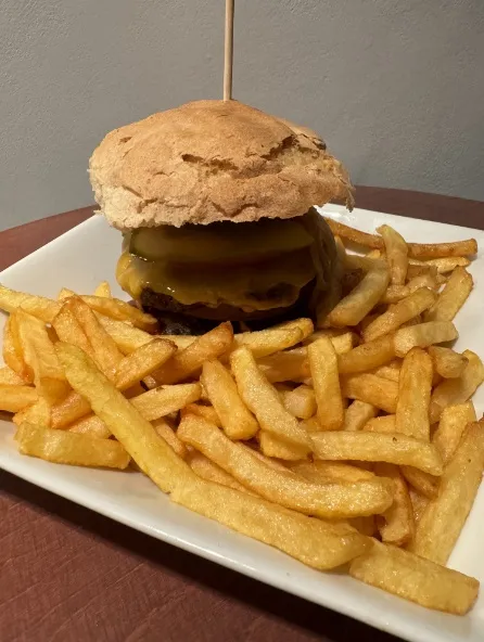 House-minced beef burger with fresh bun and crispy baked fries at Distinto